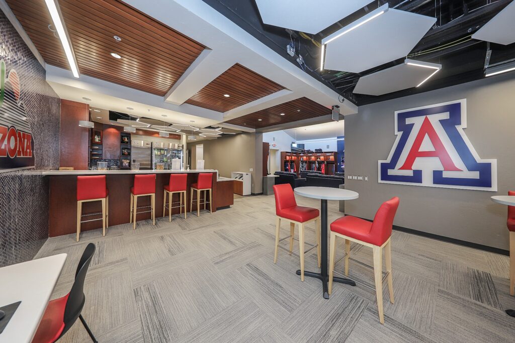 Interior shot of the clubhouse lounge there is a seating area and a kitchen space. You can see the entrance to the lockers.