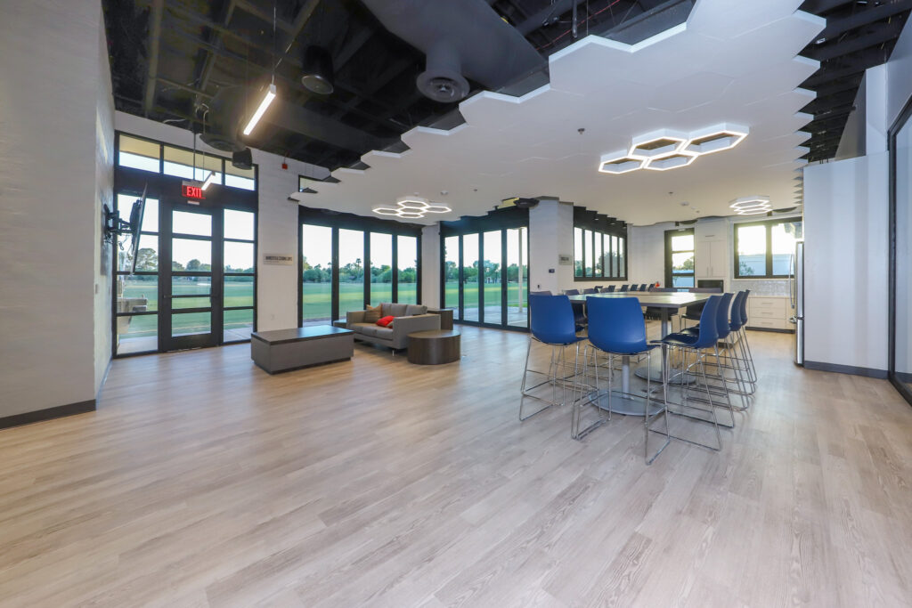 Interior of golf clubhouse with seating and honeycomb ceiling light fixtures.