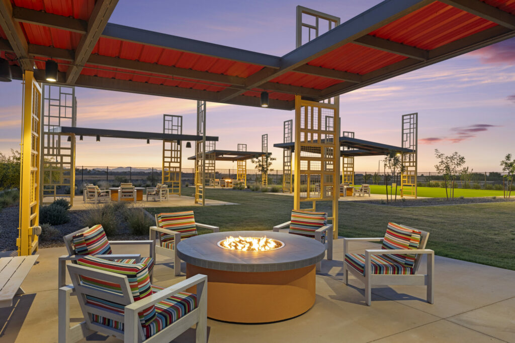 Outdoor fire pit wit red shade structure and chairs
