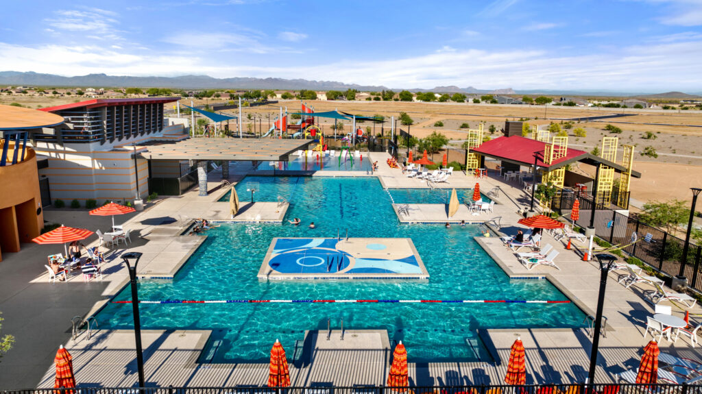 aerial of outdoor pool with red umbrellas and pool chairs