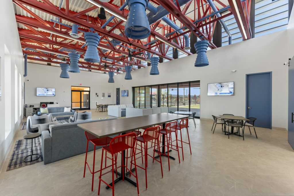 interior of open dining space with metal red features on the ceiling and blue light fixtures.