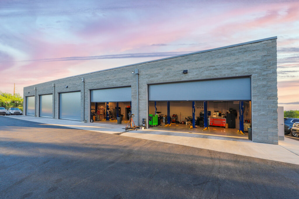 Exterior of car service bays with open rolling garage doors