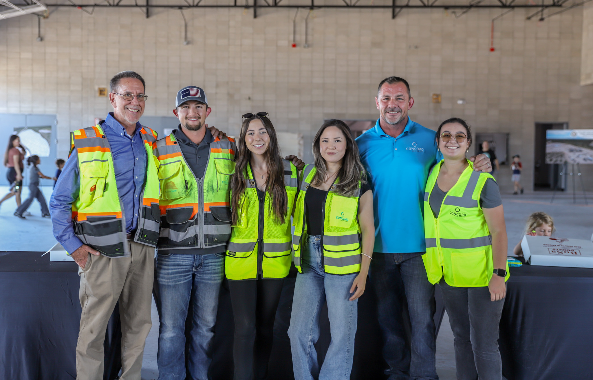 six employee owners most in their safety vests posing together at a site tour event in Tucson