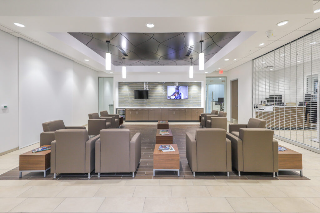 Tan chairs in lobby waiting area with high vaulted ceiling