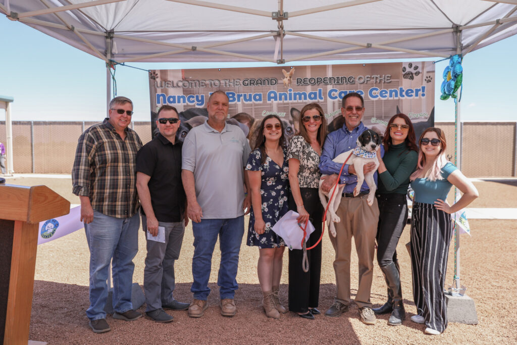 Concord Employee Owners in front of banner, one holding a dog
