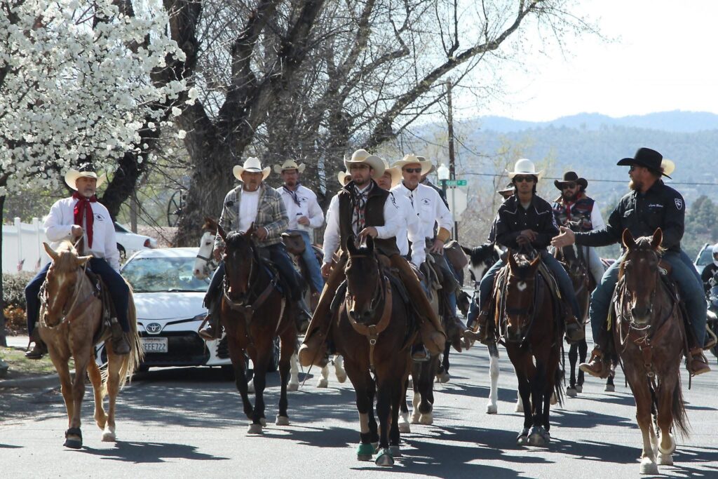 group of people riding horses in western garb